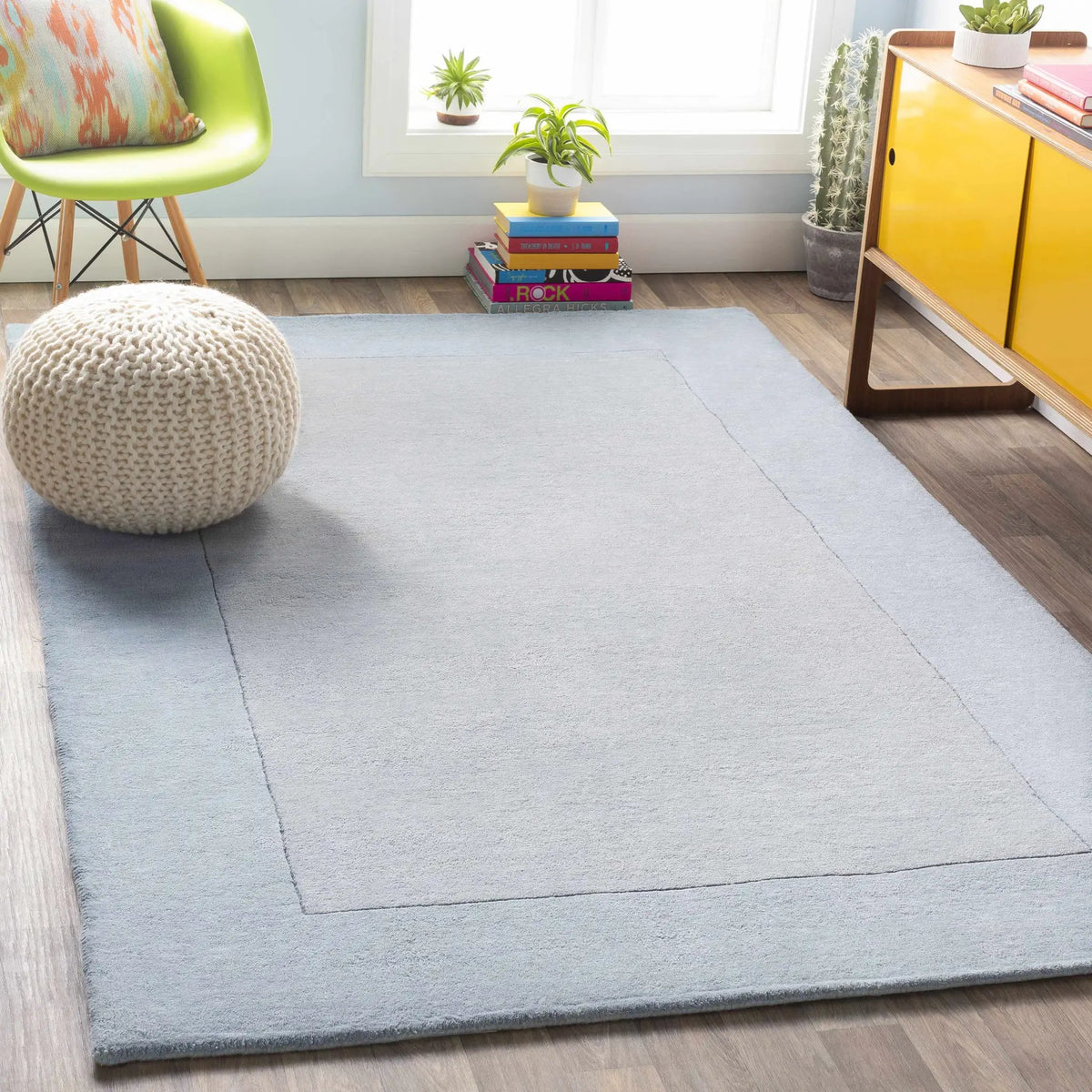 Arkabutla Solid Blue Bordered Wool Rug, installed in a room