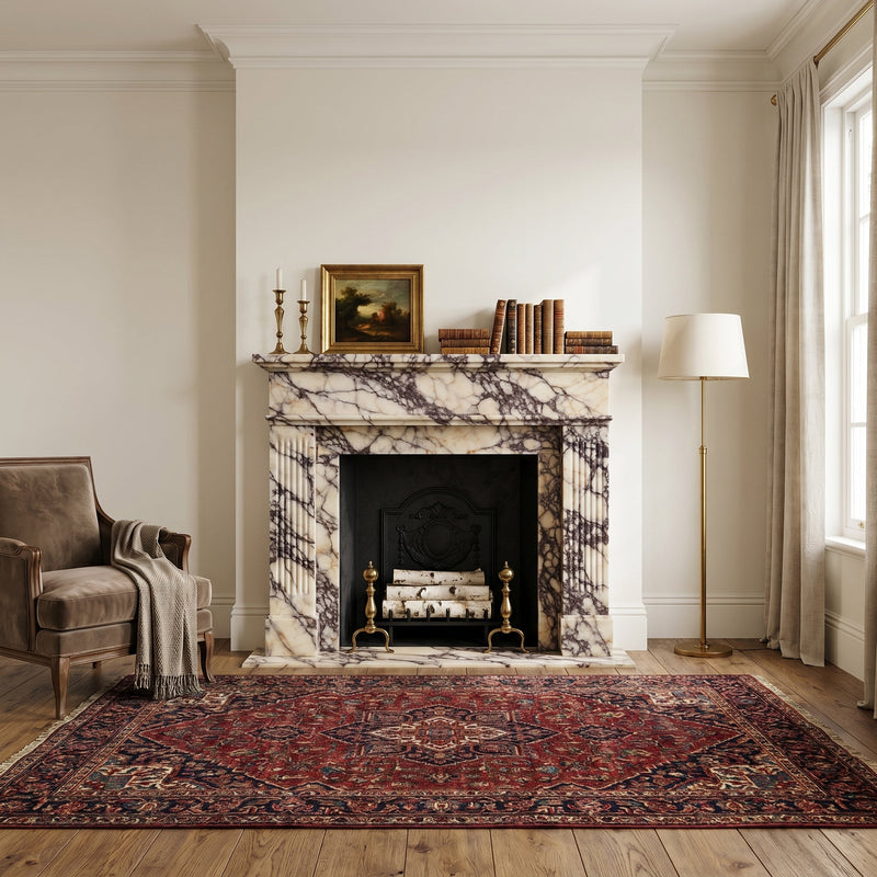 Living room with marble fireplace, armchair, and patterned rug.