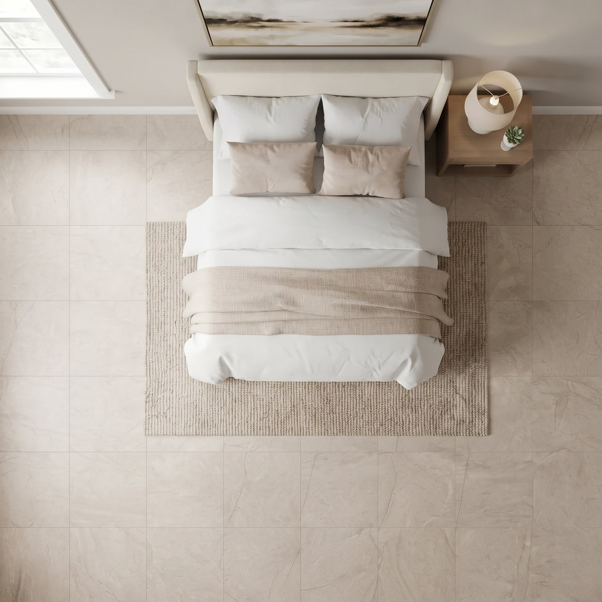 Overhead view of a neatly made bed with white bedding and beige pillows, placed on a woven beige rug in a bright, modern bedroom with light stone tile flooring and a wooden nightstand.